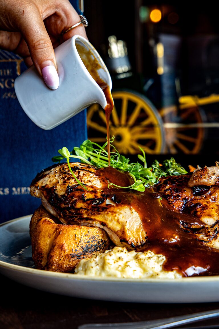 Gravy poured over roast chicken and Yorkshire pudding