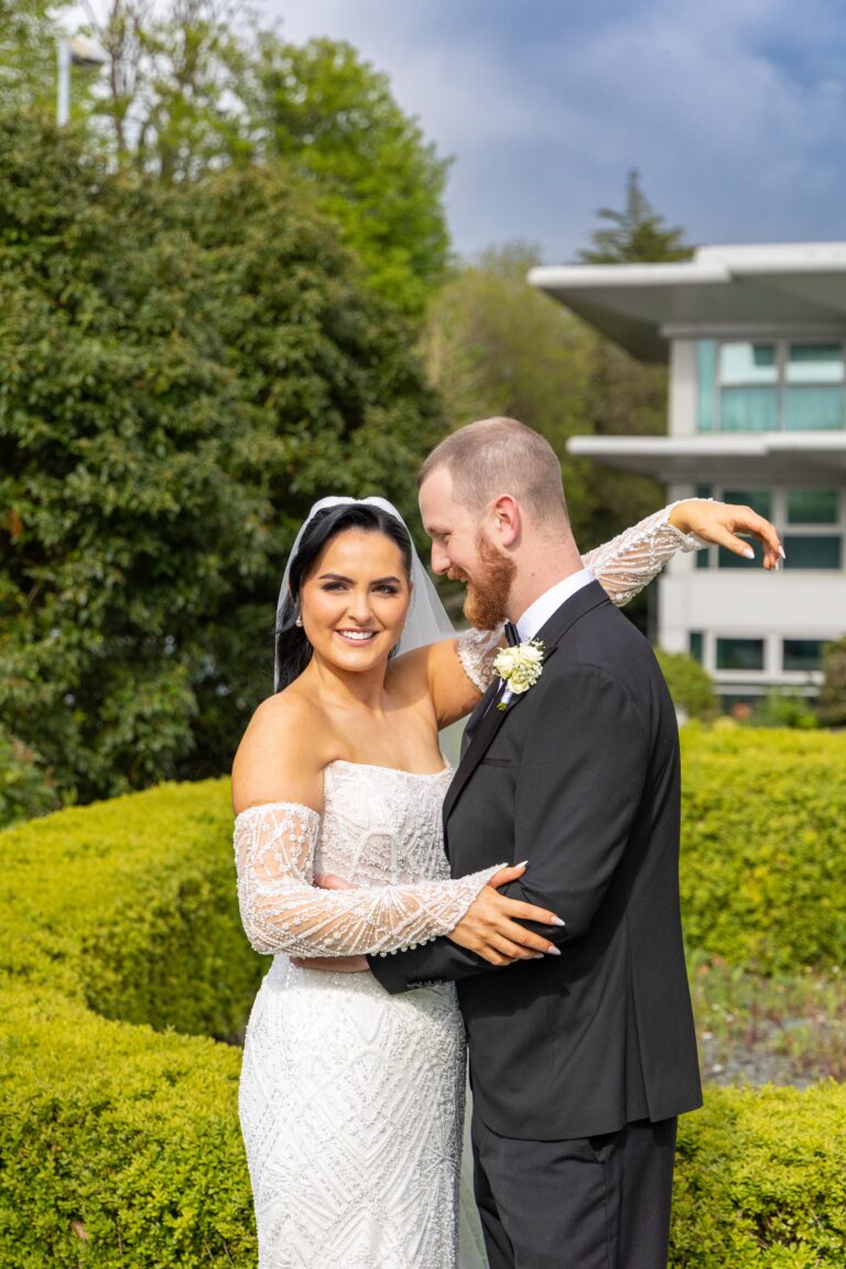 Bride and groom embracing in garden wedding portrait