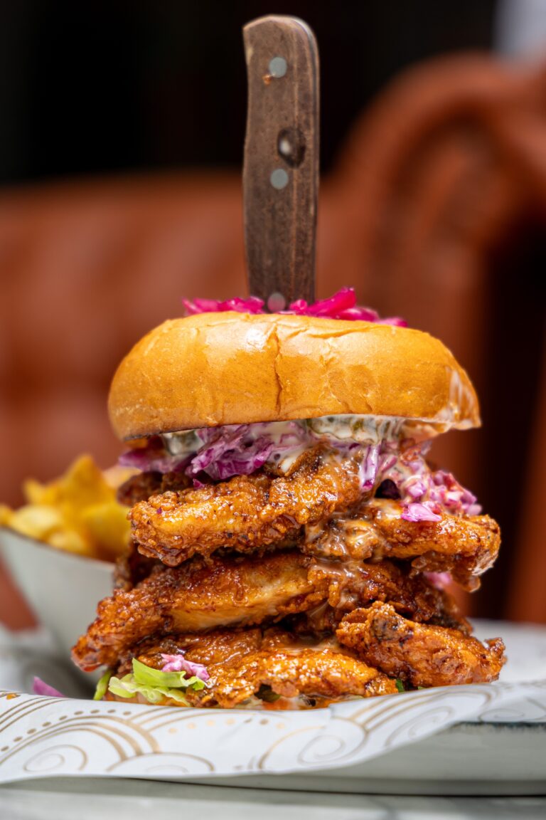 Stacked fried chicken burger with coleslaw and sauce