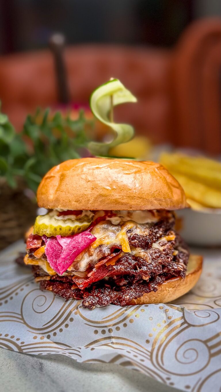 Gourmet beef burger with cheese, bacon and pickles